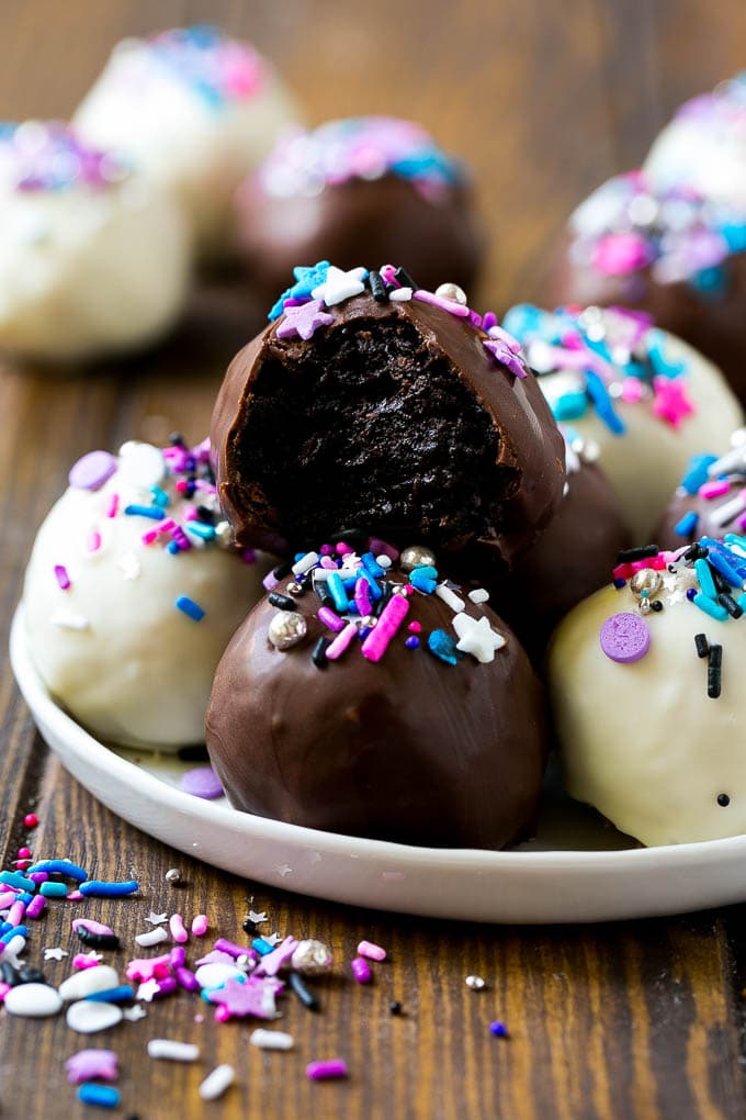Oreo Balls Recipe | Oreo Truffles | Homemade Candy #truffles #candy #oreos #chocolate #sprinkles #dessert #christmas #sraye A plate of dark and white chocolate Oreo balls topped with colorful sprinkles.