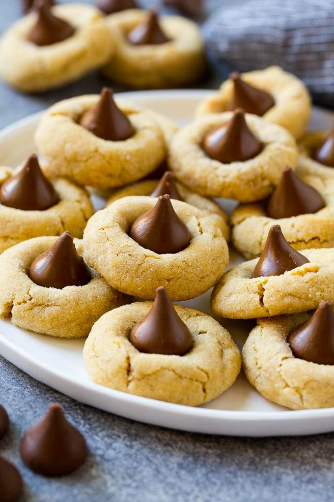 Peanut Butter Blossoms Recipe | Hershey Kiss Cookies | Chocolate Peanut Butter Cookies #cookies #peanutbutter #chocolate #dessert #baking #christmas #christmascookies #sraye A serving plate of peanut butter blossoms.