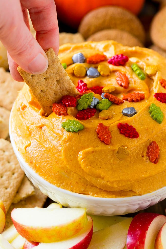 Pumpkin Dip Recipe | Dessert Dip | Pumpkin Pie Dip #pumpkin #dessert #dip #fall #thanksgiving #sraye A bowl of pumpkin dip with a graham cracker scooping some out.