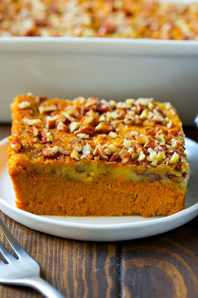 Pumpkin Dump Cake Recipe | Pumpkin Cake | Pumpkin Pie Cake #pumpkin #cake #pecans #fall #thanksgiving #dessert #sraye A slice of pumpkin dump cake topped with pecans.
