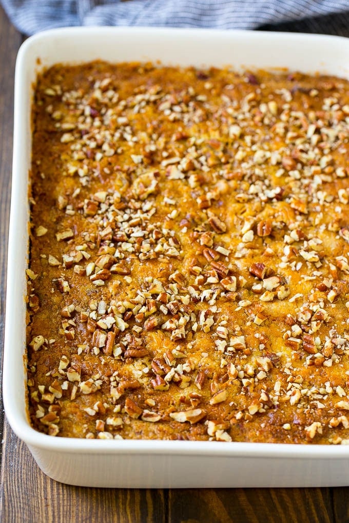 Pumpkin Dump Cake Recipe | Pumpkin Cake | Pumpkin Pie Cake #pumpkin #cake #pecans #fall #thanksgiving #dessert #sraye A pan of pumpkin dump cake topped with chopped pecans.