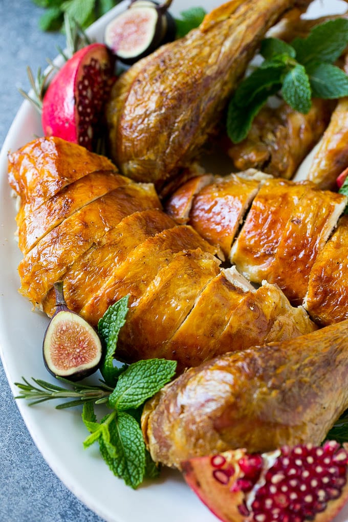 Roast Turkey Recipe | Thanksgiving Turkey | Holiday Turkey | Baked Turkey #turkey #thanksgiving #christmas #dinner #glutenfree #sraye Sliced roast turkey on a serving platter with rosemary, pomegranate and figs.