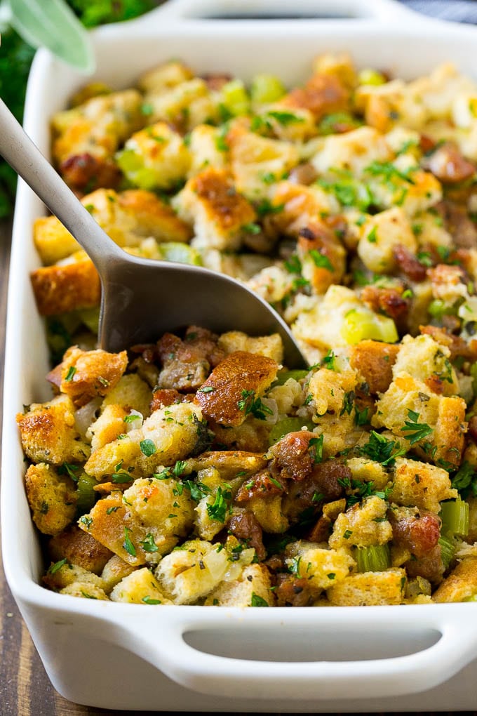 Sausage Stuffing Recipe | Thanksgiving Stuffing | Make Ahead Stuffing #stuffing #thanksgiving #sausage #sidedish #dinner #sraye A baking dish of sausage stuffing with a serving spoon in it.