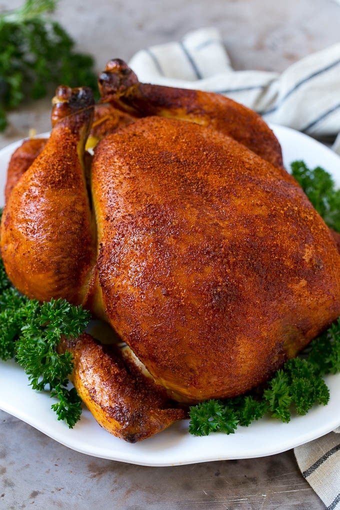 Smoked Chicken Recipe | Whole Smoked Chicken | BBQ Chicken #chicken #smoker #BBQ #dinner #sraye #glutenfree #lowcarb Smoked chicken on a serving platter garnished with parsley.