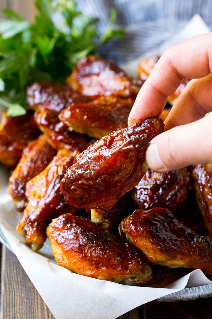 Smoked Chicken Wings | Barbecue Chicken Wings | BBQ Chicken Wings #chicken #wings #bbq #barbecue #appetizer #dinner #sraye A pile of smoked chicken wings with a hand reaching out for one.