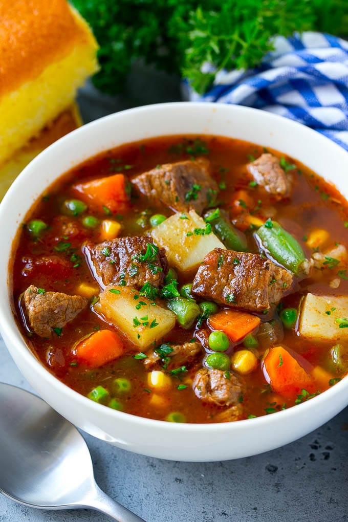 Vegetable Beef Soup Recipe | Beef Vegetable Soup | Beef Soup #beef #veggies #soup #dinner #glutenfree #sraye A bowl of vegetable beef soup with carrots, celery, onions, potatoes, tomatoes, corn and peas.