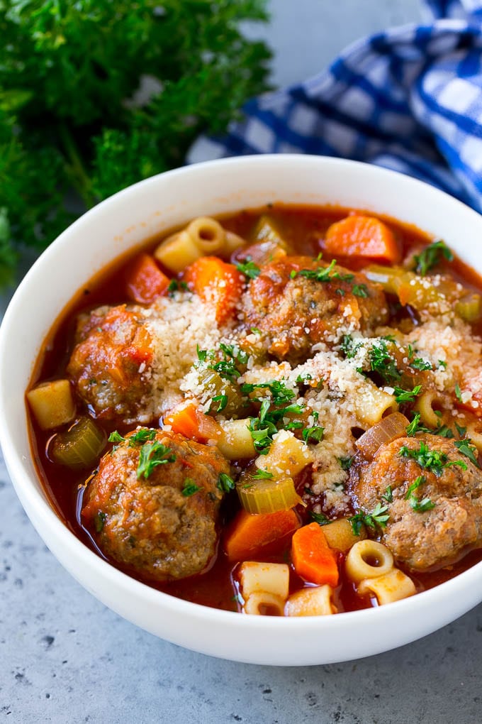 Italian Meatball Soup Recipe | Meatball Soup | Beef Meatballs #meatballs #beef #soup #italian #dinner #sraye #comfortfood A bowl of meatball soup topped with chopped parsley and grated cheese.