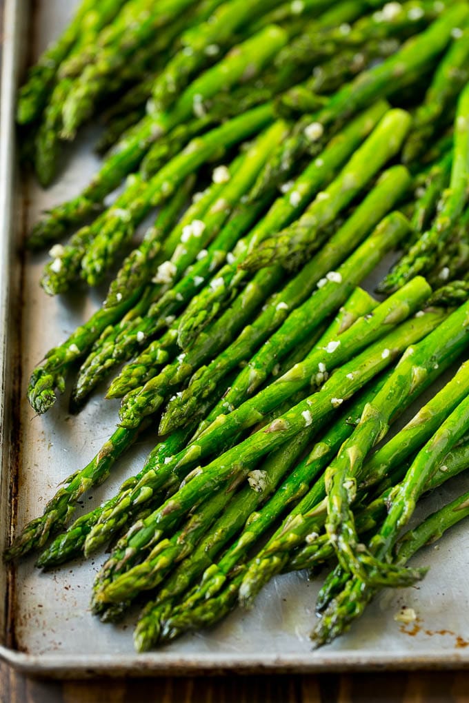 Roasted Asparagus Recipe | Baked Asparagus | Asparagus Side Dish #asparagus #garlic #sidedish #keto #lowcarb #dinner #sraye Roasted stalks with garlic and olive oil on a baking sheet.