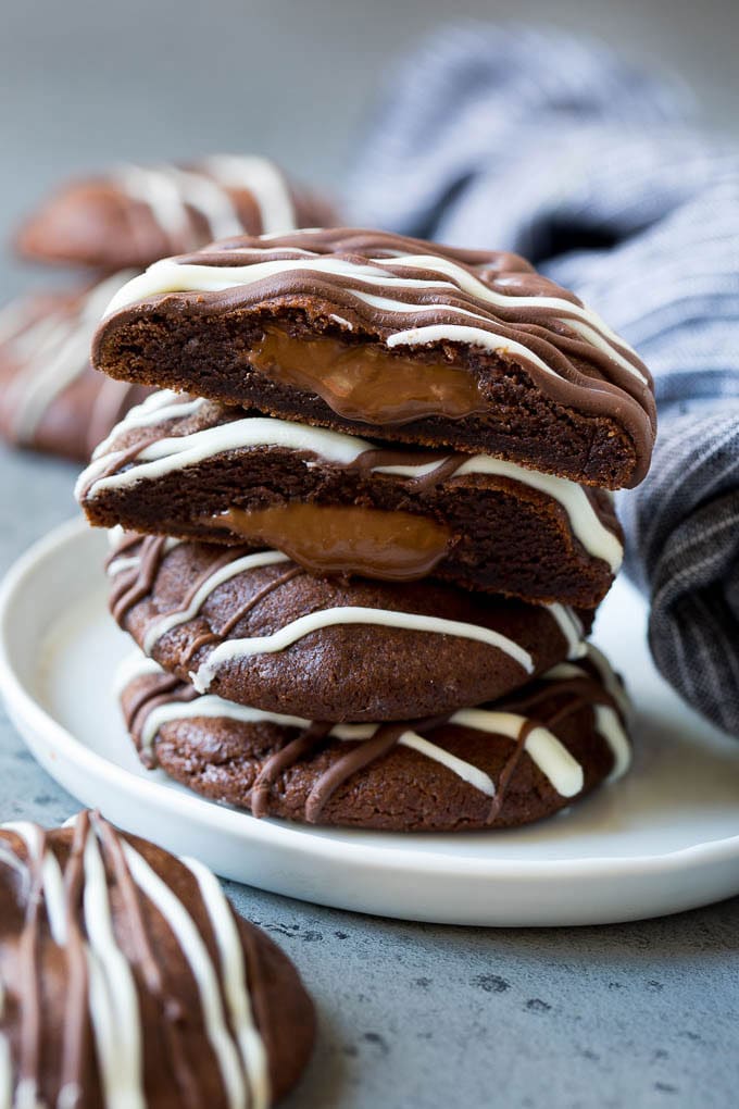 Nutella Cookies Recipe | Nutella Stuffed Cookies | Chocolate Cookies #nutella #chocolate #cookies #baking #dessert #sraye A stack of Nutella cookies on a plate with one cut open.
