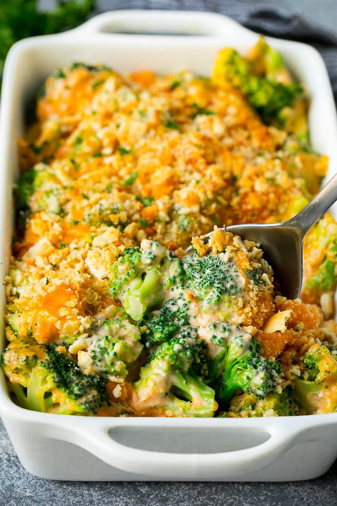 Broccoli Casserole Recipe | Broccoli and Cheese Casserole | Baked Broccoli #broccoli #cheese #casserole #sidedish #dinner #sraye A pan of broccoli casserole with a serving spoon in it.