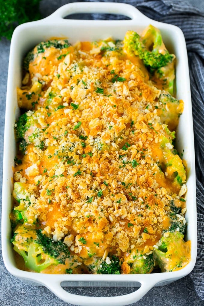 Broccoli Casserole Recipe | Broccoli and Cheese Casserole | Baked Broccoli #broccoli #cheese #casserole #sidedish #dinner #sraye A pan of broccoli casserole topped with crackers, melted cheese and parsley.