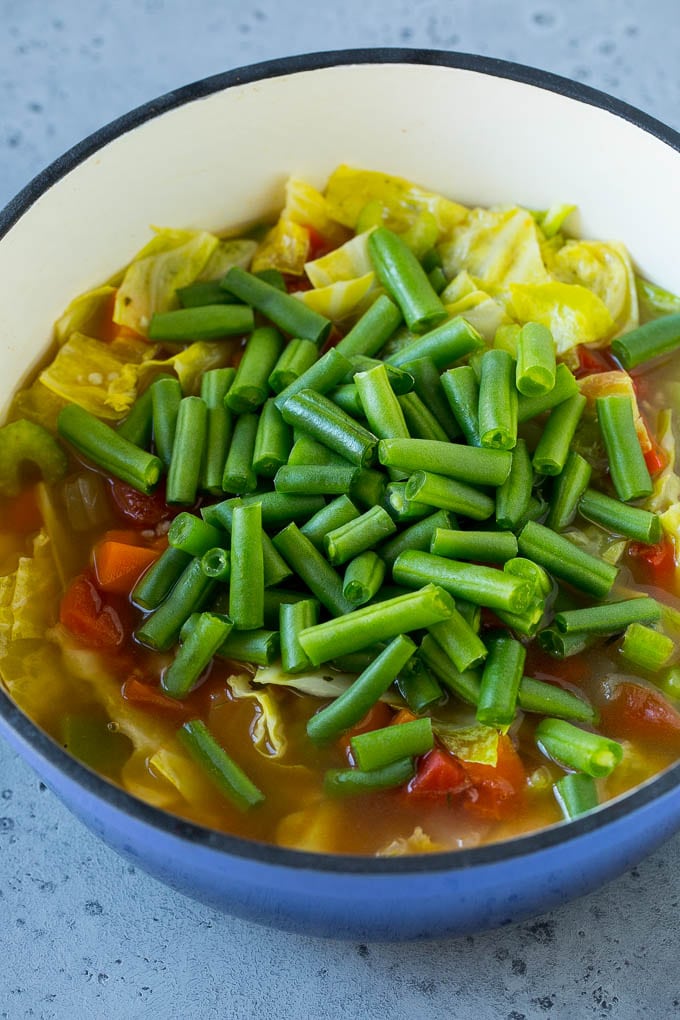 Cabbage Soup Recipe | Vegetable Soup | Veggie Soup | Healthy Soup #soup #healthy #cleaneating #cabbage #vegetables #veggies #dinner #sraye Green beans in a pot of cooked veggies.