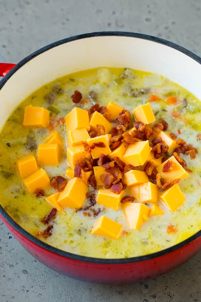 Cheeseburger Soup Recipe | Hamburger Soup | Cheese Soup #soup #groundbeef #hamburger #cheese #bacon #dinner #sraye Potato soup base with cubes of Velveeta cheese and bacon being stirred in.