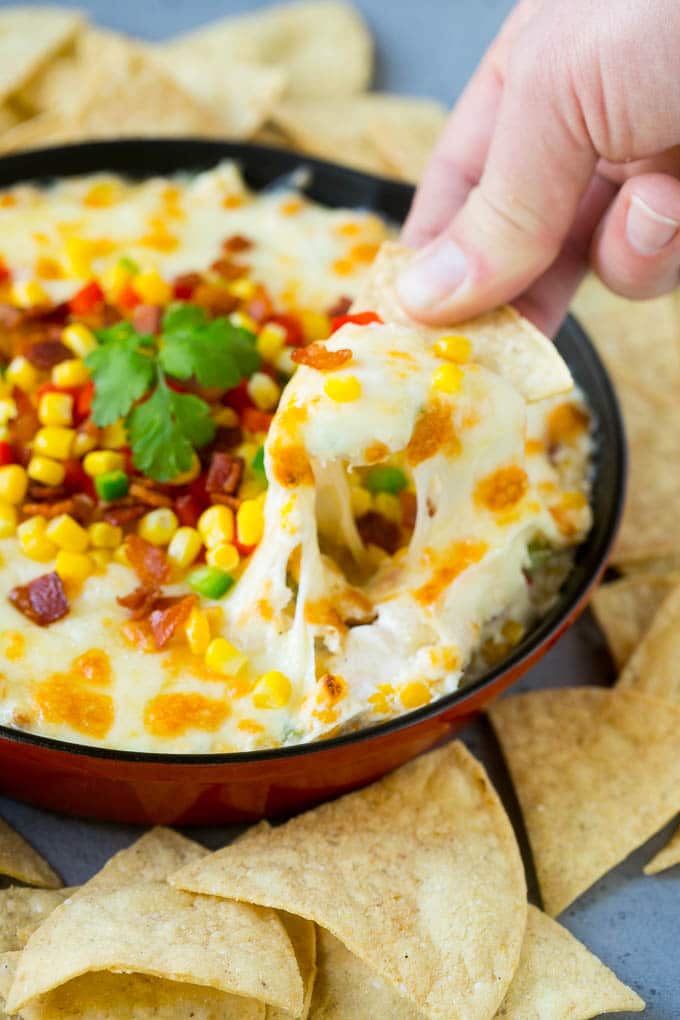 Corn Dip Recipe | Hot Cheese Dip | Bacon Dip #corn #dip #bacon #cheese #appetizer #snack #sraye A chip scooping up a serving of corn dip.