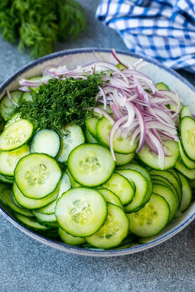 Creamy Cucumber Salad Recipe | German Cucumber Salad | Cucumber Salad #cucumber #salad #dinner #lunch #sraye #cucumbersalad Thinly sliced cucumbers, red onion and fresh dill in a mixing bowl.