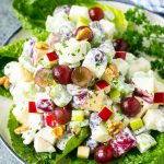 Waldorf salad with apples, grapes, celery and pecans, served on a bed of lettuce leaves.
