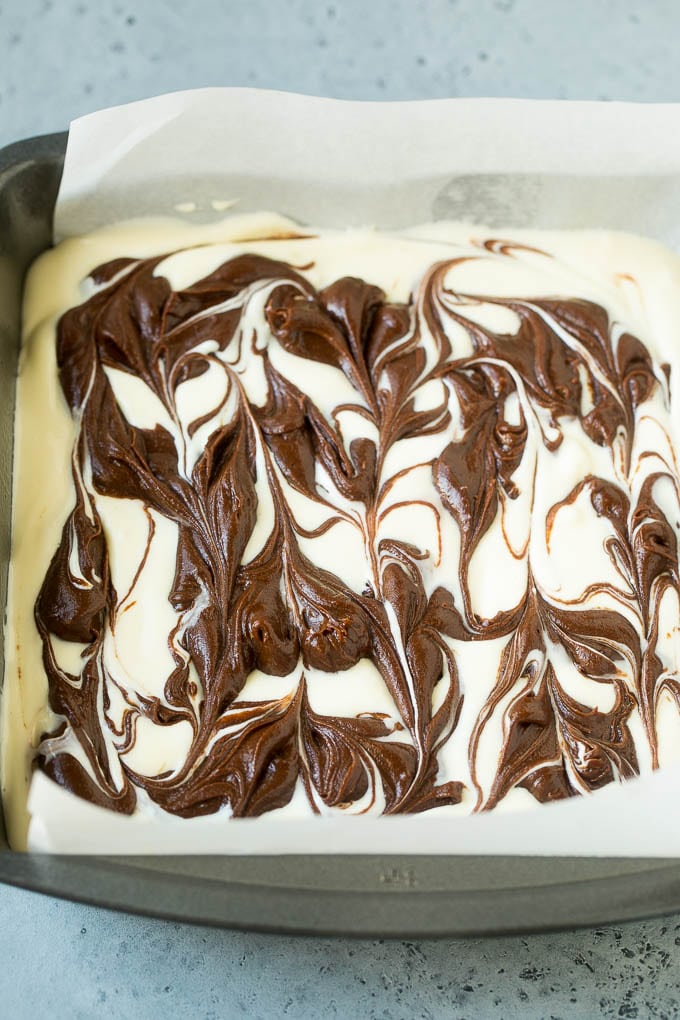 Cheesecake Brownies Recipe | Cream Cheese Brownies | Homemade Brownies #brownies #cheesecake #chocolate #dessert #sraye Swirled chocolate and cream cheese brownie batters in a baking pan.