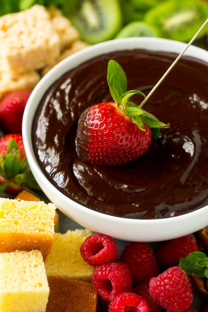 Chocolate Fondue Recipe | Chocolate Sauce | Chocolate Dip #chocolate #dessert #glutenfree #fondue #sraye A strawberry being dipped into a bowl of fondue.