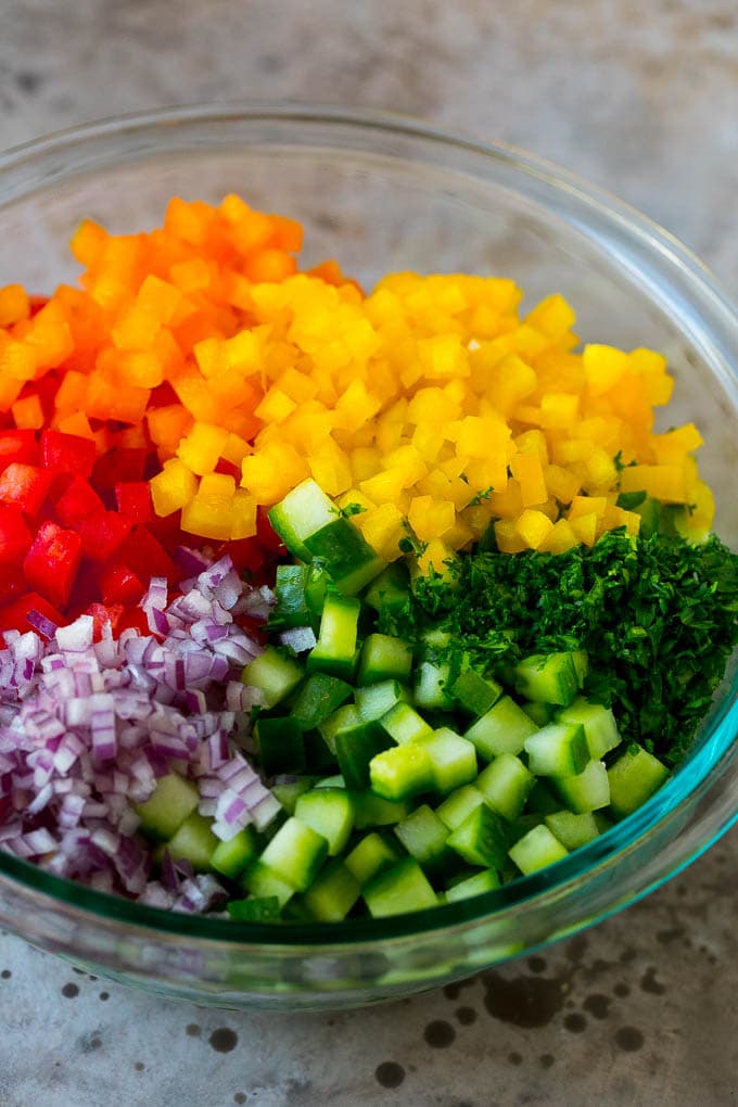 Israeli Salad Recipe | Cucumber Salad | Tomato Salad | Chopped Salad #salad #cleaneating #healthy #glutenfree #lowcarb #keto #sidedish #lunch #sraye Chopped peppers, cucumbers, tomatoes and onions in a bowl.