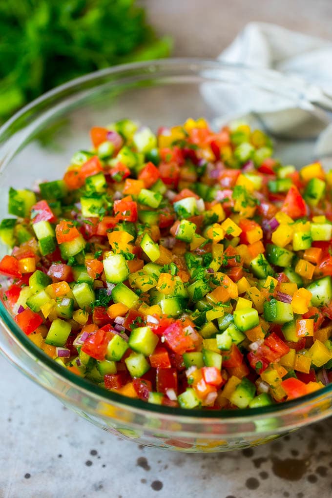 Israeli Salad Recipe | Cucumber Salad | Tomato Salad | Chopped Salad #salad #cleaneating #healthy #glutenfree #lowcarb #keto #sidedish #lunch #sraye Israeli salad with cucumbers and tomatoes in a serving bowl.