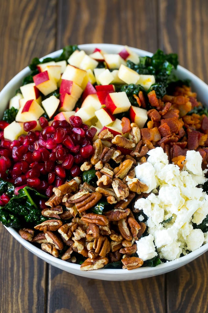 Apple Kale Salad Recipe | Kale Recipe | Fall Salad #kale #apples #bacon #salad #feta #dinner #lunch #sraye Kale salad topped with apples, bacon, pecans, pomegranate and feta cheese.