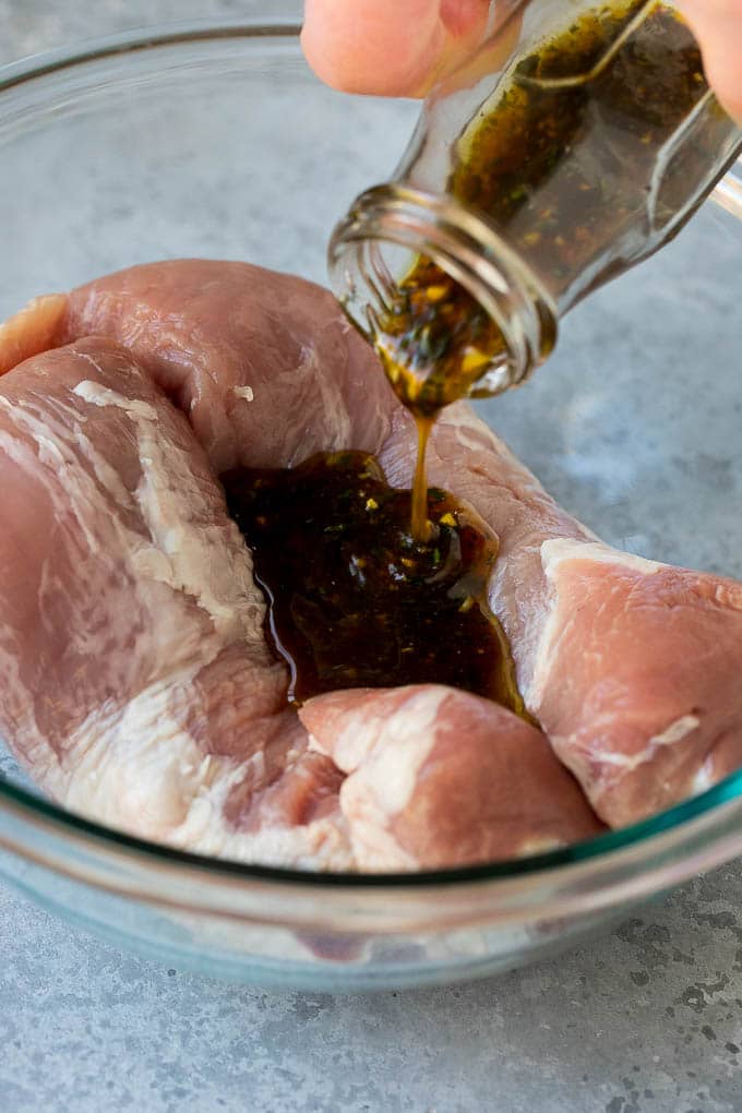 Marinated Pork Tenderloin Recipe | Pork Tenderloin Marinade | Pork Marinade #pork #porktenderloin #marinade #dinner #grilling #sraye Marinade being poured over pork tenderloin.
