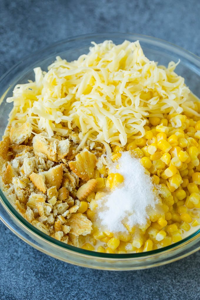 Scalloped Corn | Corn Casserole #corn #casserole #cheese #sidedish #dinner #sraye Corn, crushed crackers, seasonings and shredded cheese in a bowl.