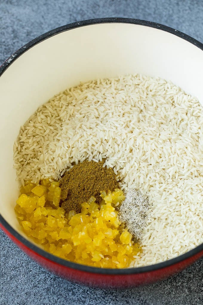 Black Beans and Rice Recipe | Cuban Black Beans | Beans and Rice #beans #rice #blackbeans #sidedish #glutenfree #dinner #sraye Onions, garlic, white rice and spices in a pot.