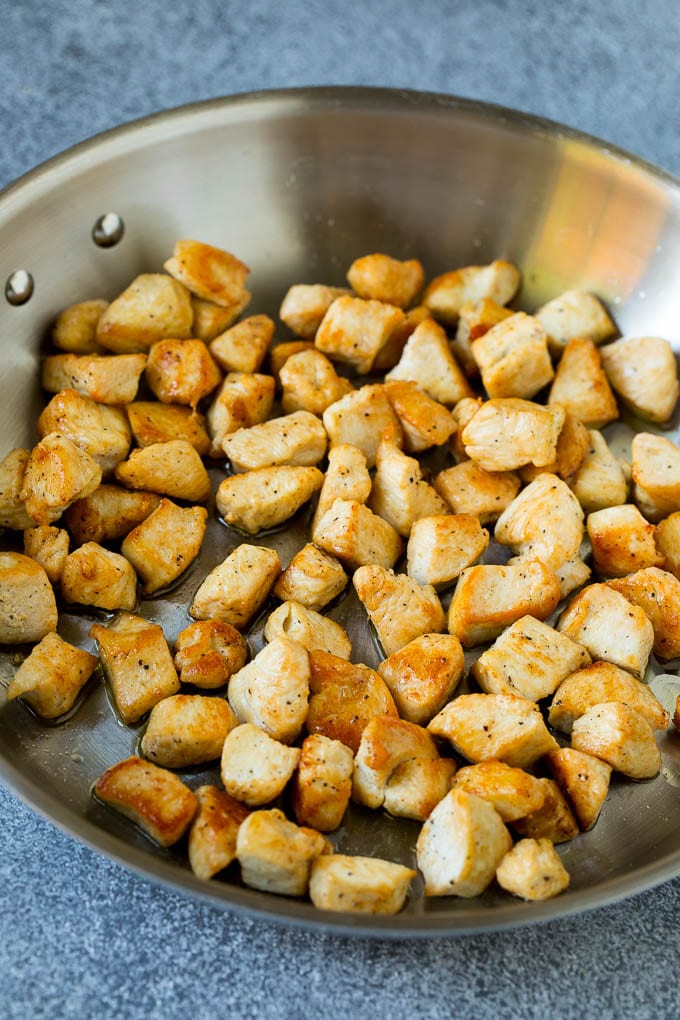 Chicken Fried Rice Recipe | Chinese Fried Rice #rice #chicken #peas #carrots #sidedish #dinner #sraye Cooked chicken pieces in a metal pan.