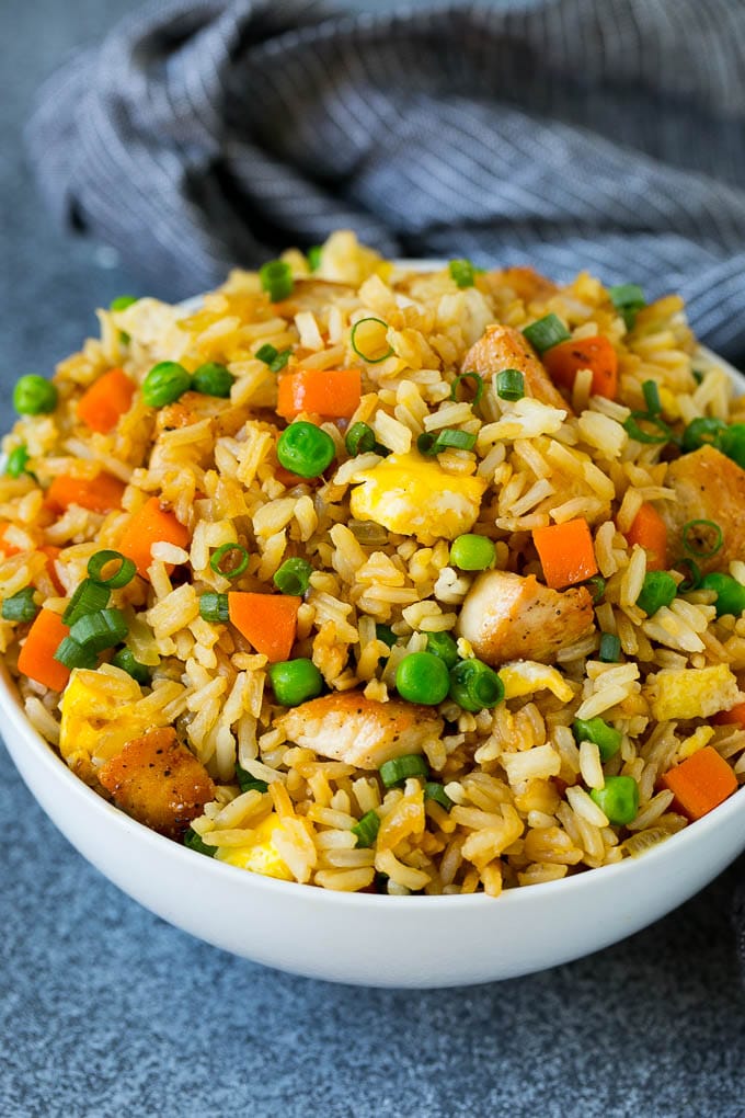 Chicken Fried Rice Recipe | Chinese Fried Rice #rice #chicken #peas #carrots #sidedish #dinner #sraye A bowl of chicken fried rice topped with sliced green onions.