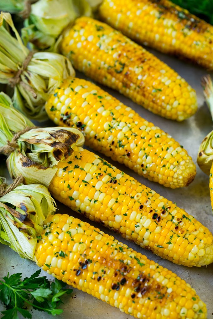 Grilled Corn on the Cob Recipe | Corn Recipe #corn #grilling #summer #sidedish #dinner #sraye Grilled corn on the cob topped with garlic and herb butter on a sheet pan.