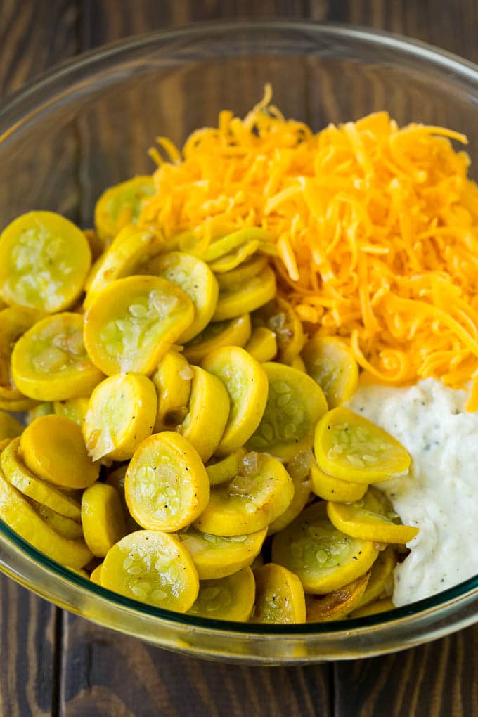 Squash Casserole Recipe | Vegetable Casserole | Zucchini Casserole #casserole #squash #zucchini #cheese #sidedish #sraye Cooked yellow squash, creamy sauce and cheddar cheese in a mixing bowl.