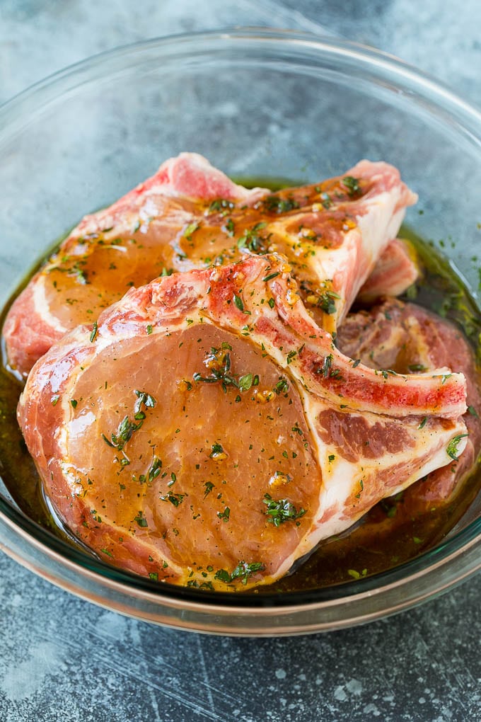 Grilled Pork Chops | Pork Chop Marinade #porkchops #grilling #pork #marinade #dinner #sraye Pork chops in a bowl of marinade.