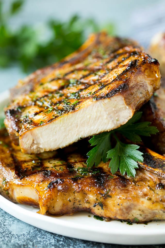 Grilled Pork Chops | Pork Chop Marinade #porkchops #grilling #pork #marinade #dinner #sraye Grilled pork chops with a cut chop on top of the stack.
