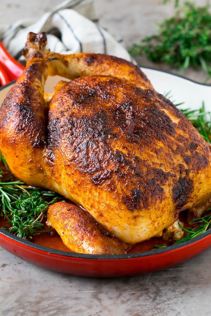 Rotisserie Chicken Recipe | Roasted Chicken #chicken #dinner #sraye #comfortfood Rotisserie chicken in a skillet garnished with fresh herbs.