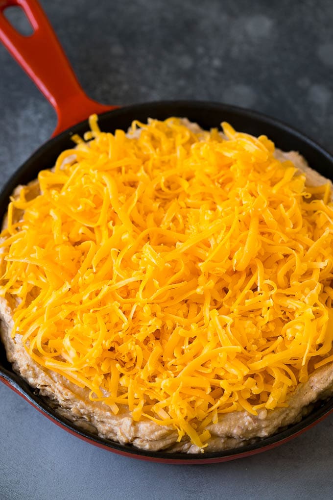 Bean Dip Recipe | Mexican Dip #dip #appetizer #mexicanfood #beans #cheese #sraye The base topped with freshly shredded cheese.