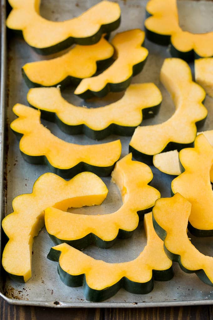 Roasted Acorn Squash | Acorn Squash Recipe #squash #winter #sidedish #dinner #sraye Sliced acorn squash on a sheet pan.