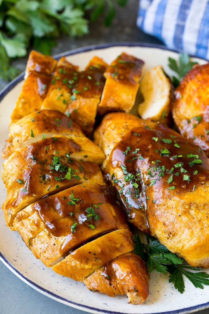 Slow Cooker Chicken Breast Recipe | Crock Pot Chicken Breast | Chicken and Gravy #chicken #slowcooker #crockpot #gravy #dinner #sraye Sliced crock pot chicken breasts on a serving plate.