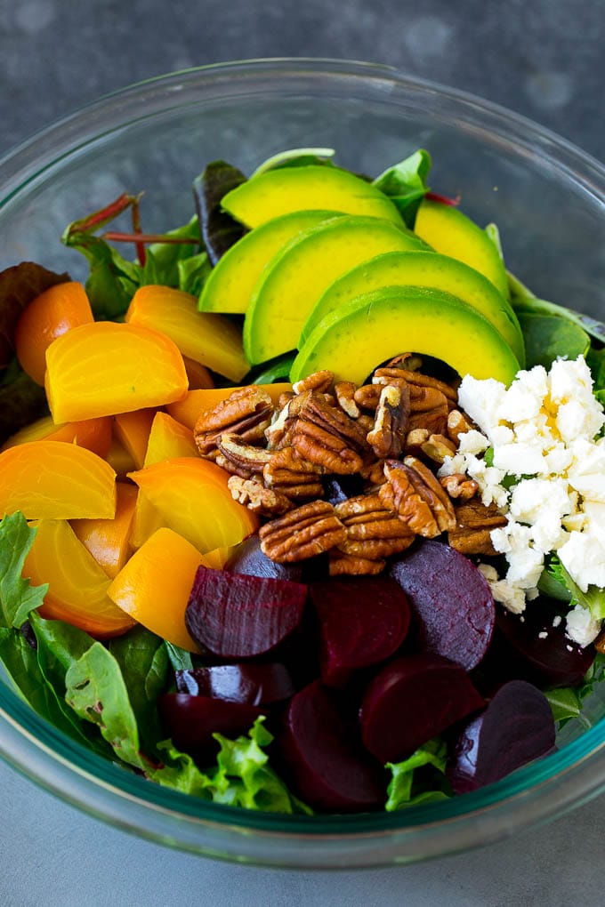 Beet Salad Recipe #beets #avocado #feta #salad #dinner #sraye Red and yellow beets, salad greens, feta cheese, avocado and pecans in a bowl.