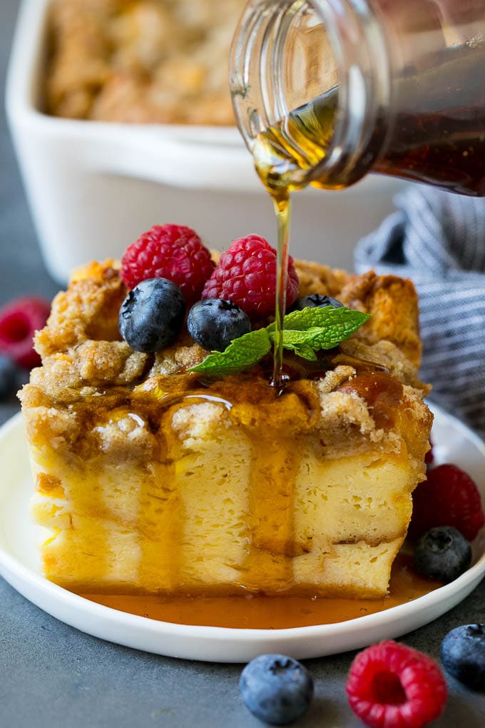 French Toast Casserole Recipe | French Toast Bake #frenchtoast #casserole #breakfast #brunch #sraye #bread A piece of french toast casserole with syrup being poured over the top.