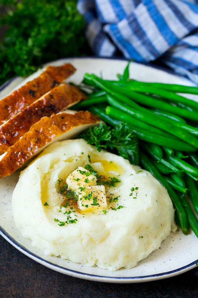 Garlic Mashed Potatoes Recipe #garlic #potatoes #mashedpotatoes #sidedish #dinner #thanksgiving #sraye A plate with garlic mashed potatoes, green beans and sliced turkey.