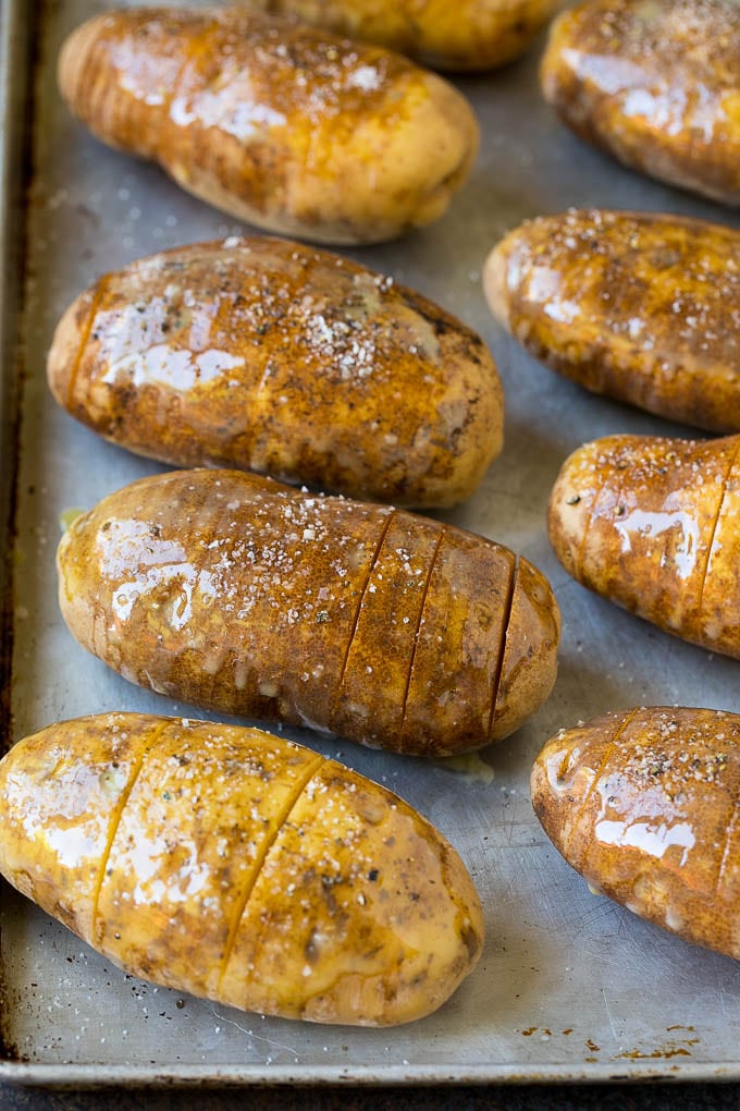 Hasselback Potatoes Recipe #potatoes #bacon #sidedish #cheese #dinner #sraye Potatoes on a sheet pan coated in olive oil and butter.