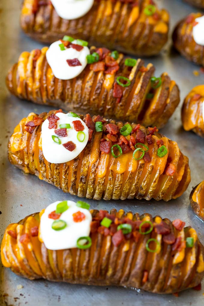 Hasselback Potatoes Recipe #potatoes #bacon #sidedish #cheese #dinner #sraye Hasselback potatoes filled with melted cheese, then topped with bacon, sour cream and green onions.