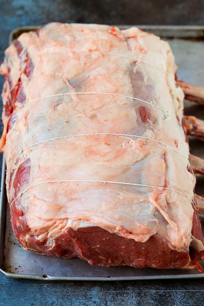 Prime Rib Recipe #primerib #beef #roast #dinner #thanksgiving #christmas #keto #lowcarb #sraye A tied standing rib roast on a sheet pan.