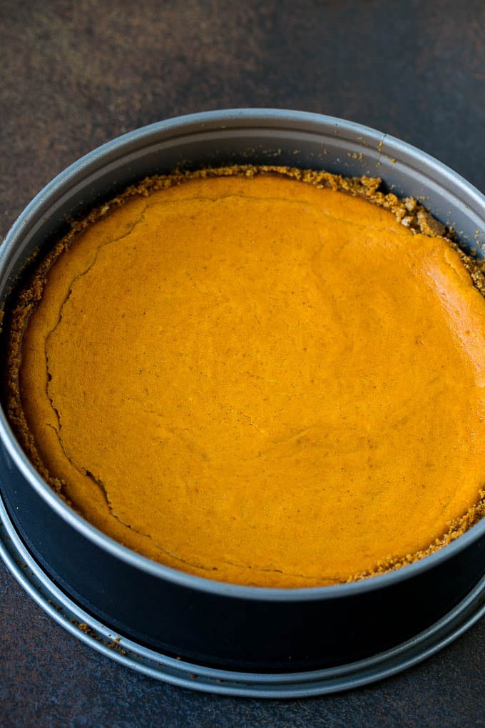 Pumpkin Pie Cheesecake Recipe | Pumpkin Cheesecake #cake #cheesecake #pumpkin #fall #thanksgiving #dessert #sraye A baked pumpkin cheesecake in a pan.