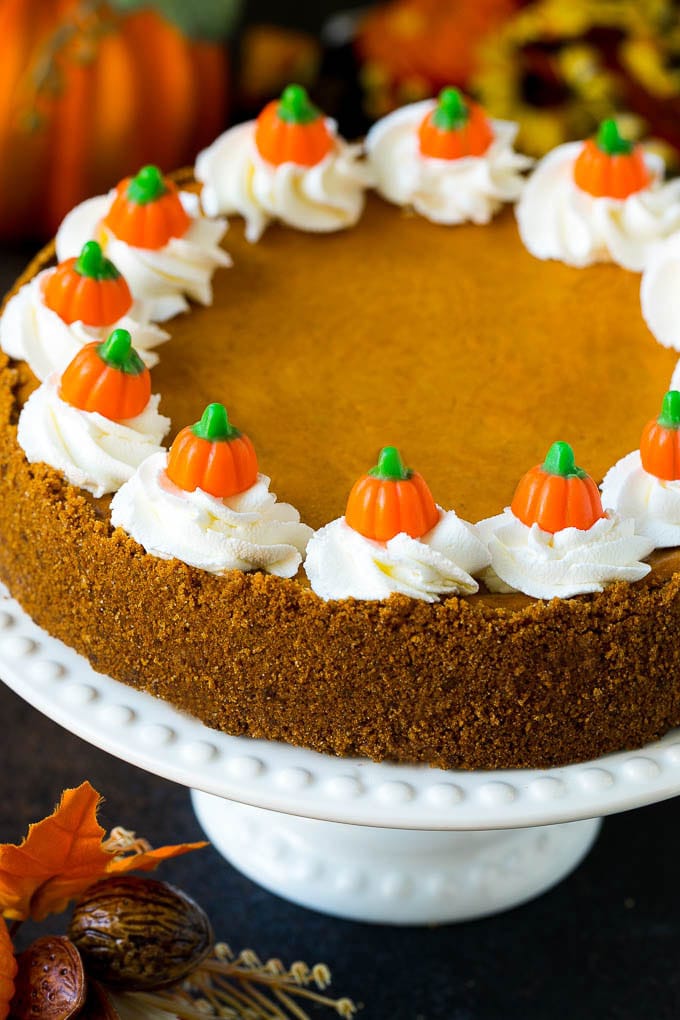 Pumpkin Pie Cheesecake Recipe | Pumpkin Cheesecake #cake #cheesecake #pumpkin #fall #thanksgiving #dessert #sraye Pumpkin pie cheesecake topped with whipped cream and candy pumpkins.