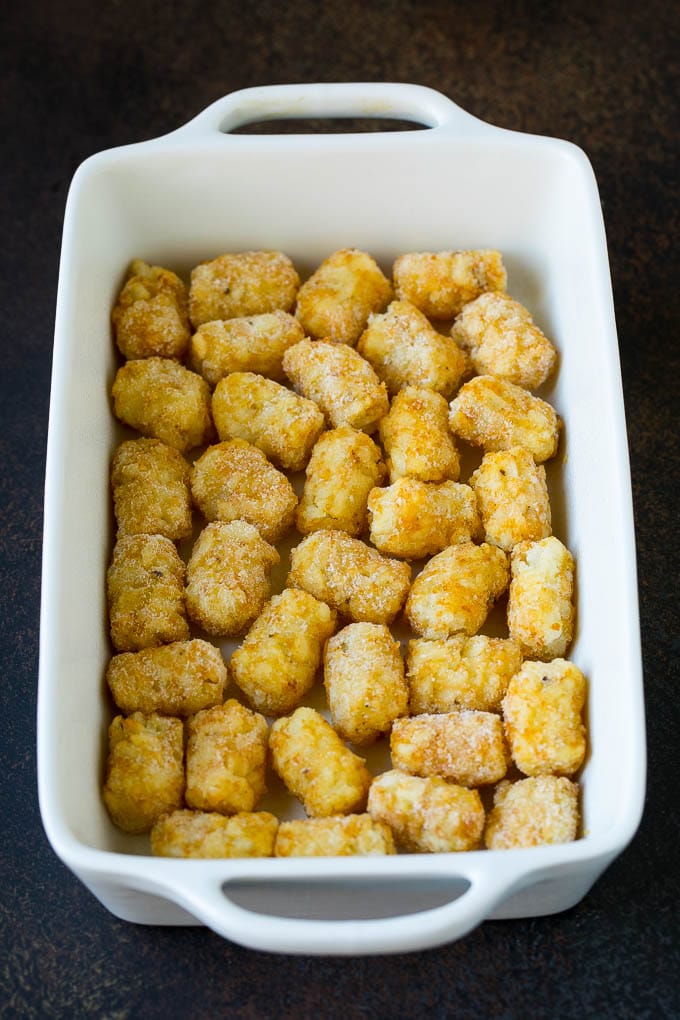 Sausage Egg Casserole Recipe | Egg Casserole #eggs #sausage #potato #cheese #casserole #breakfast #brunch #sraye Potato tots in a casserole dish.