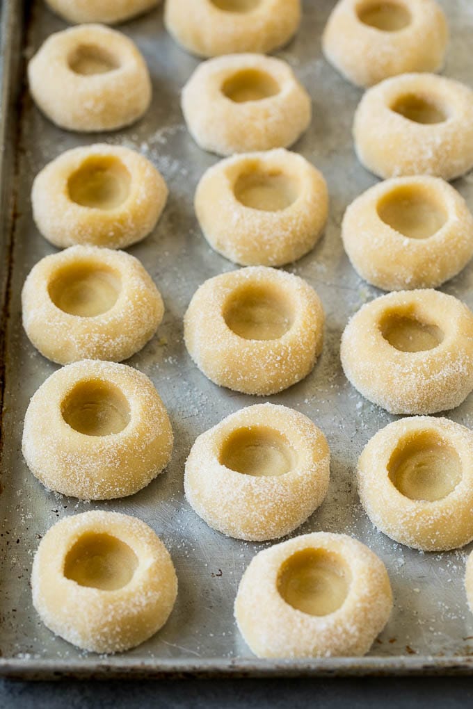 Thumbprint Cookies | Sugar Cookies #cookies #baking #christmas #dessert #sraye Balls of cookie dough with indentations in them.