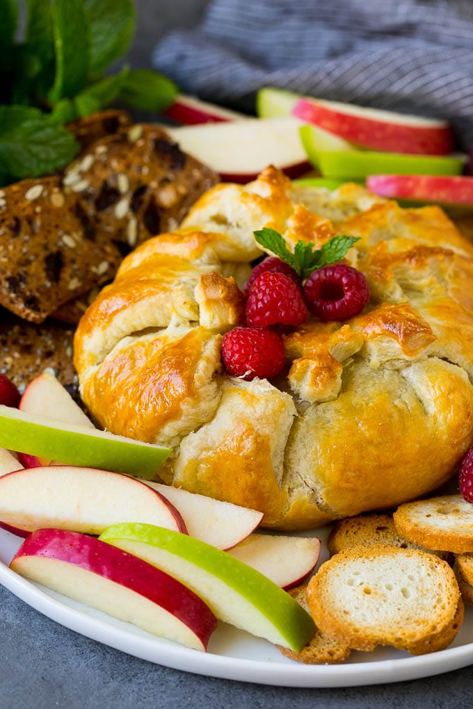 Baked Brie Recipe | Pastry Wrapped Brie #brie #cheese #appetizer #pecans #raspberries #sraye Brie wrapped in puff pastry, served with apples and crackers.