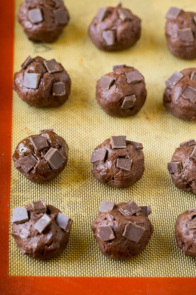 Brownie Cookies Recipe | Chocolate Cookies #cookies #brownies #chocolate #dessert #baking #sraye Balls of cookie dough with chocolate pieces pressed into the tops.